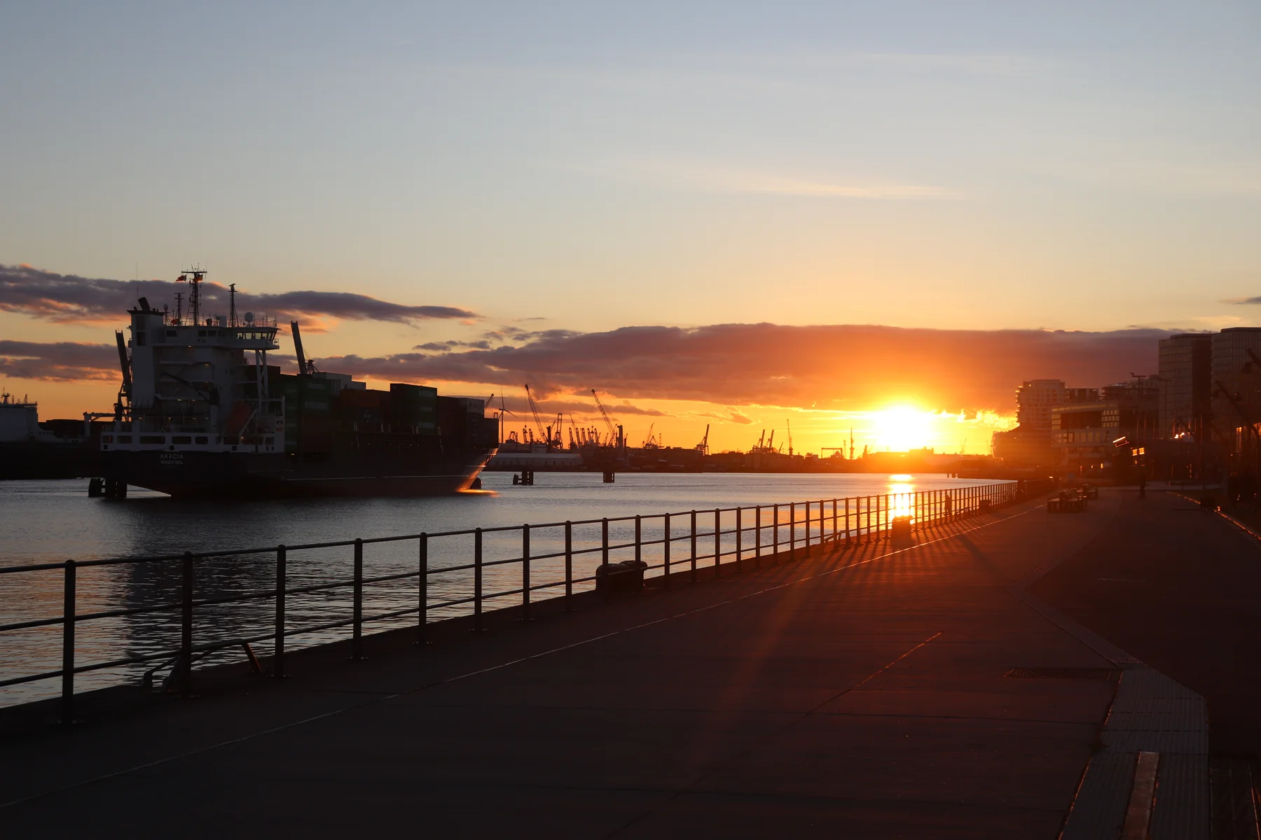 A cargo vessel and harbour infrastructure in warm evening light